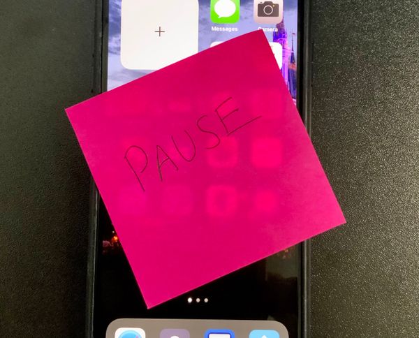 IPhone with pause post it note on screen